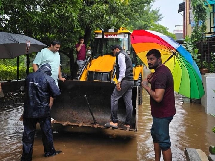 पूरस्थितीत जेसीबीच्या सहाय्याने नागरिकांना सुरक्षित स्थळी हलवताना